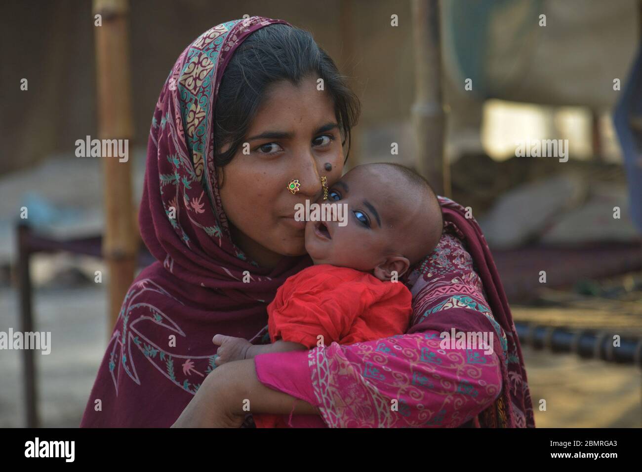 Lahore, Pakistan. Mai 2020. Die pakistanische Mutter spielt und drückt ihre Zuneigung zu ihrem Kind am Vorabend des Muttertages am Ufer des Flusses Ravi in Lahore aus. Der Muttertag wird jährlich am zweiten Sonntag im Mai weltweit gefeiert.Pakistan gemeinsam mit ihren Babys ist es eine Feier, die die Mutter der Person ehrt, sowie die Mutterschaft, die mütterlichen Bindungen und den Einfluss der Mütter in der Gesellschaft. Mother's Day stammte hauptsächlich von zwei Frauen, Julia ward Howe und Anna Jarvis. Quelle: Pacific Press Agency/Alamy Live News Stockfoto