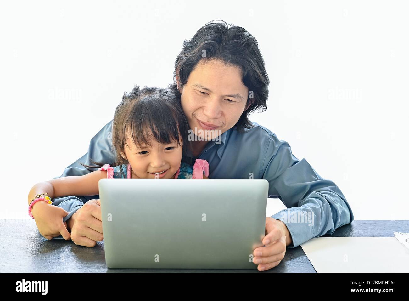 Asiatische Vater und Tochter arbeiten auf Laptop. Geschäftsmann arbeitet von zu Hause aus und beobachten Kind auf weißem Hintergrund Stockfoto