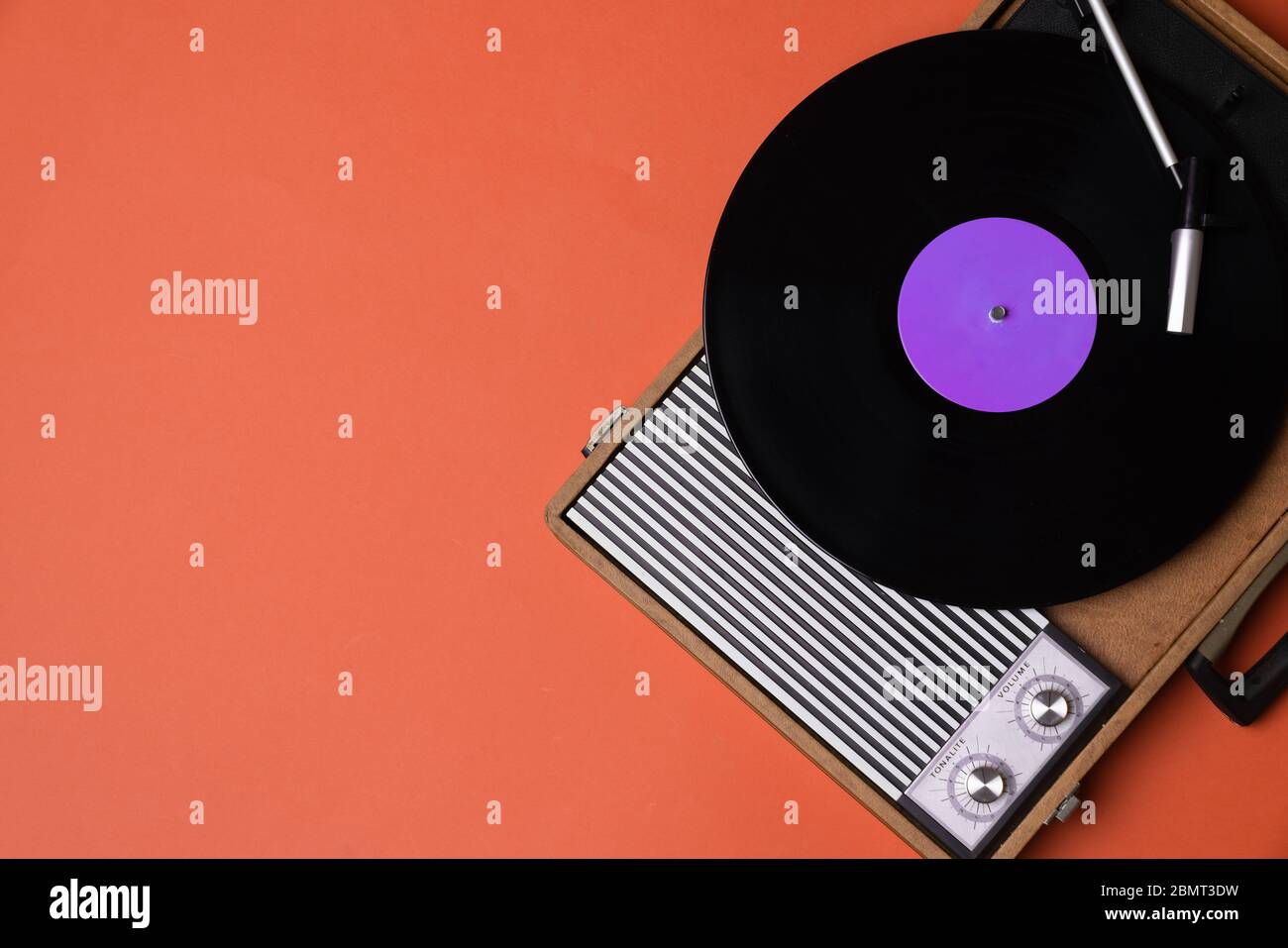 Vintage Vinyl-Player und drehbar auf einem orangefarbenen Hintergrund. Unterhaltung 70er Jahre. Musik hören. Draufsicht. Stockfoto