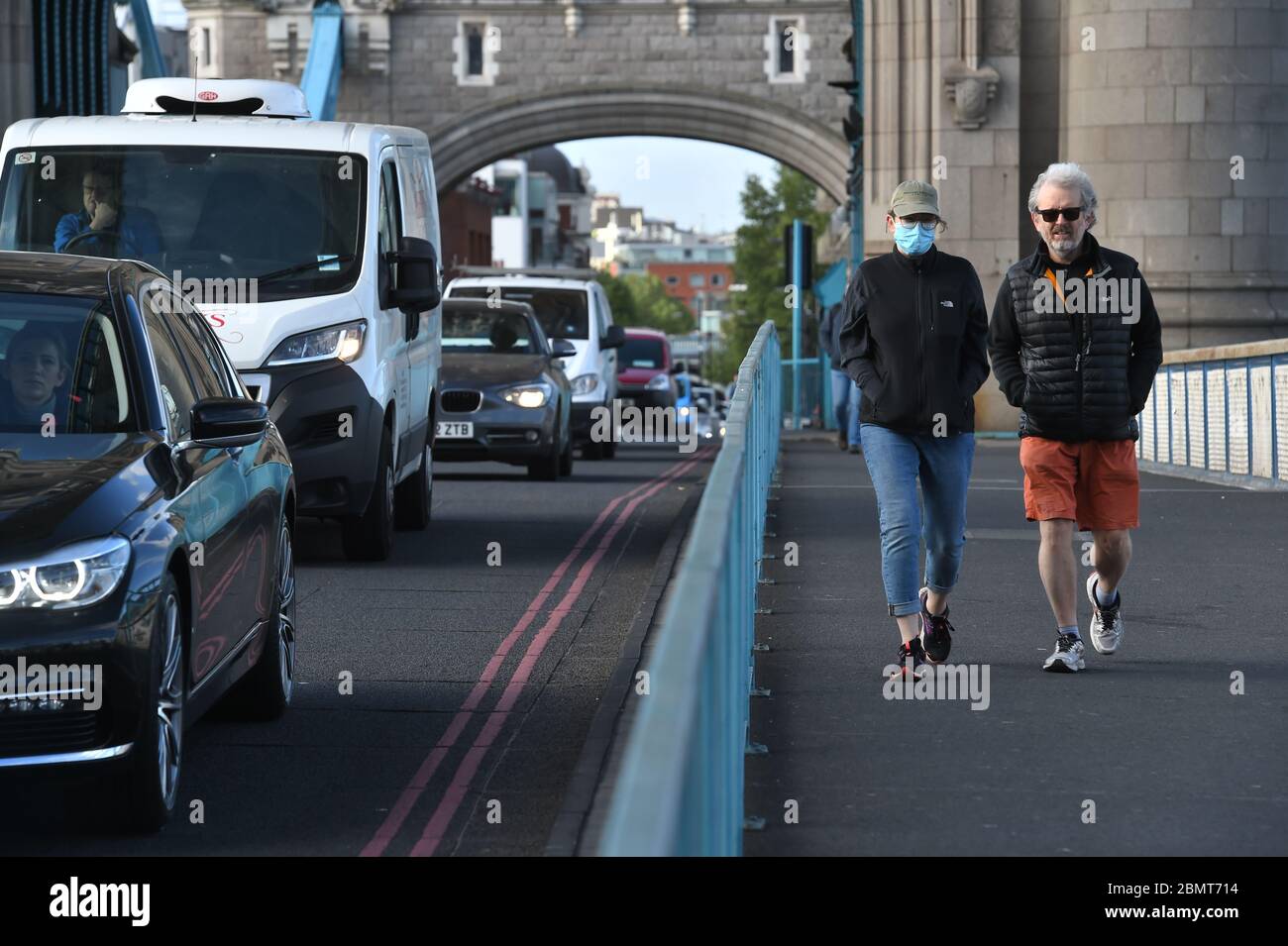Fußgänger passieren den starken Verkehr, der über die Tower Bridge in London vorbeigeht, am Morgen, nachdem Premierminister Boris Johnson sagte, dass Menschen, die nicht von zu Hause aus arbeiten können, "aktiv ermutigt" werden sollten, ab Montag wieder an ihren Arbeitsplatz zurückzukehren. Stockfoto