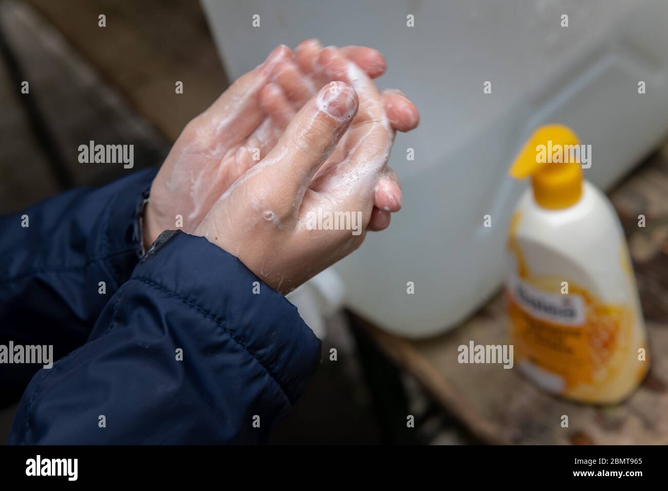 München, Deutschland. Mai 2020. Am Morgen wäscht ein Schüler der vierten Klasse unter Aufsicht auf dem Schulhof der Klenze-Schule gründlich die Hände. Zunächst kehren die Klassen zu den Schulen zurück, die nächstes Jahr ihren Abschluss machen werden. Und die Viertklässler dürfen auch in ihre Klassenzimmer zurückkehren, da die Vorschriften zur Eindämmung der Corona-Pandemie entspannt sind. Quelle: Peter Kneffel/dpa/Alamy Live News Stockfoto