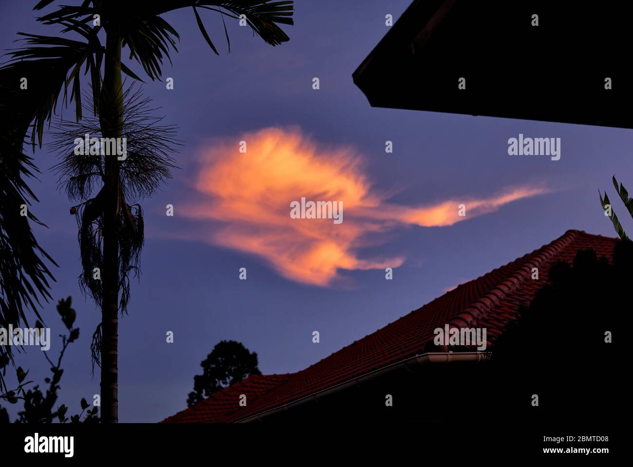 Dramatischer Himmel in der Nacht mit der untergehenden Sonne, die einen dramatischen orangefarbenen feurigen Wolkeneffekt erzeugt Stockfoto