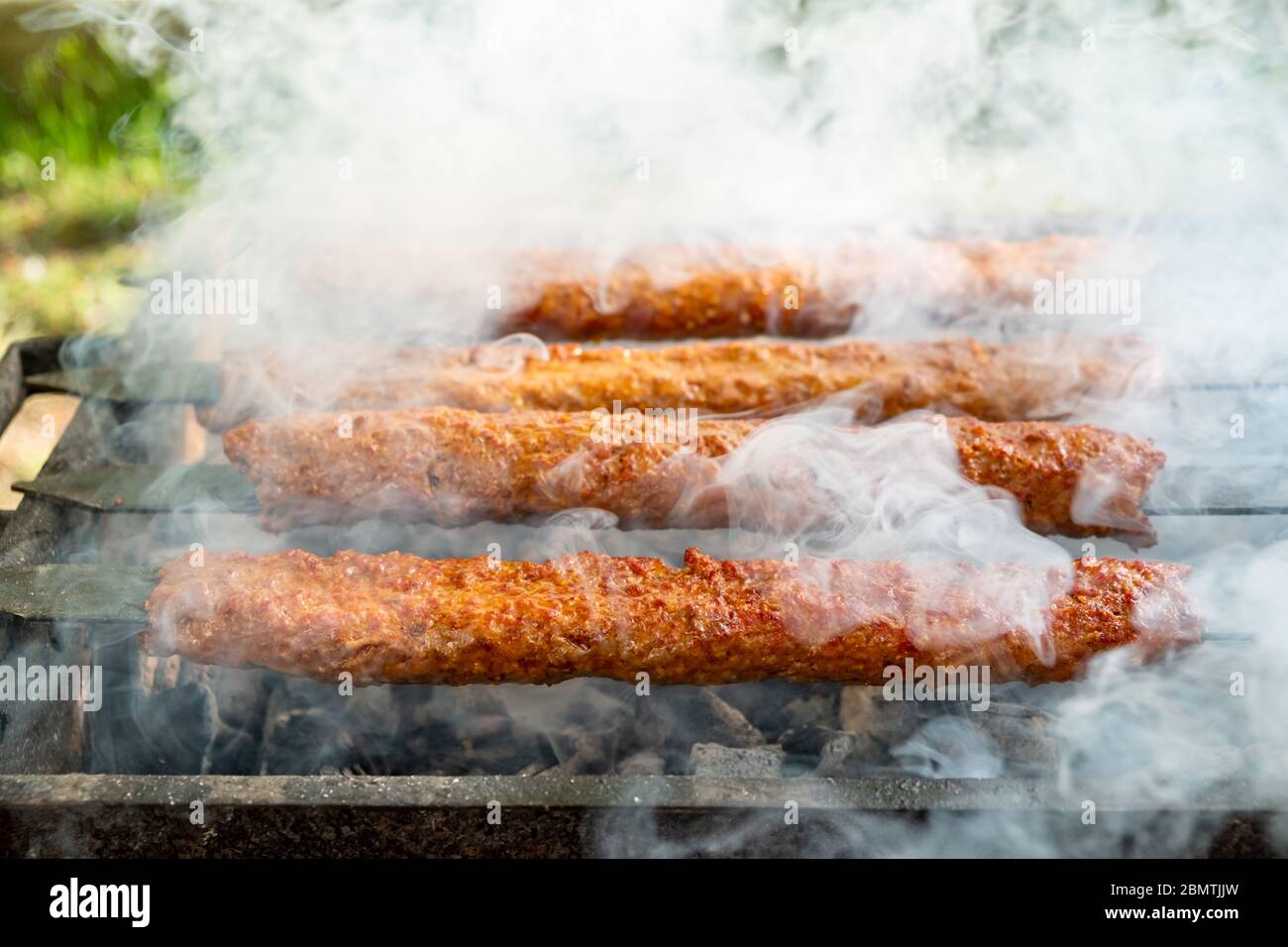 Traditionelles türkisches Adana Kebap auf dem Grill mit Spiessen zum  Abendessen. Türkische Küche Esskultur in der Türkei. Adana Kebab auf dem  mangal in der Natur Stockfotografie - Alamy