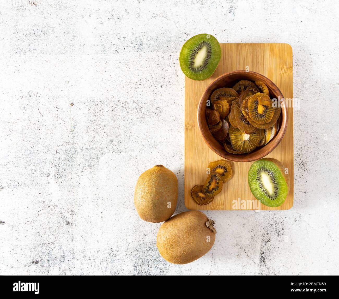 Hausgemachte Obstchips. Getrocknete Kiwi-Scheiben auf einer hellen Oberfläche Stockfoto