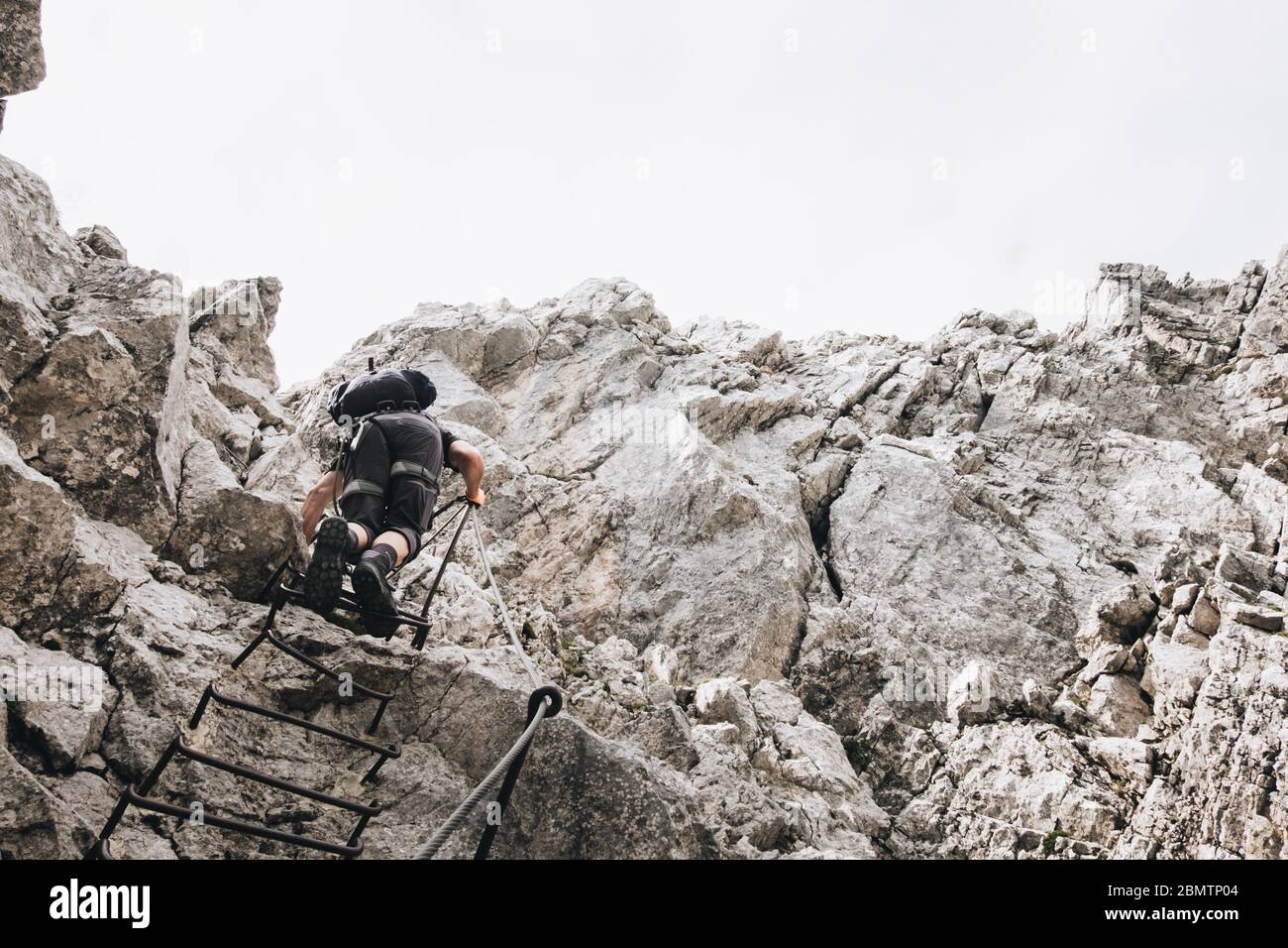 Person auf dem Weg nach oben in einem Klettersteig Stockfoto