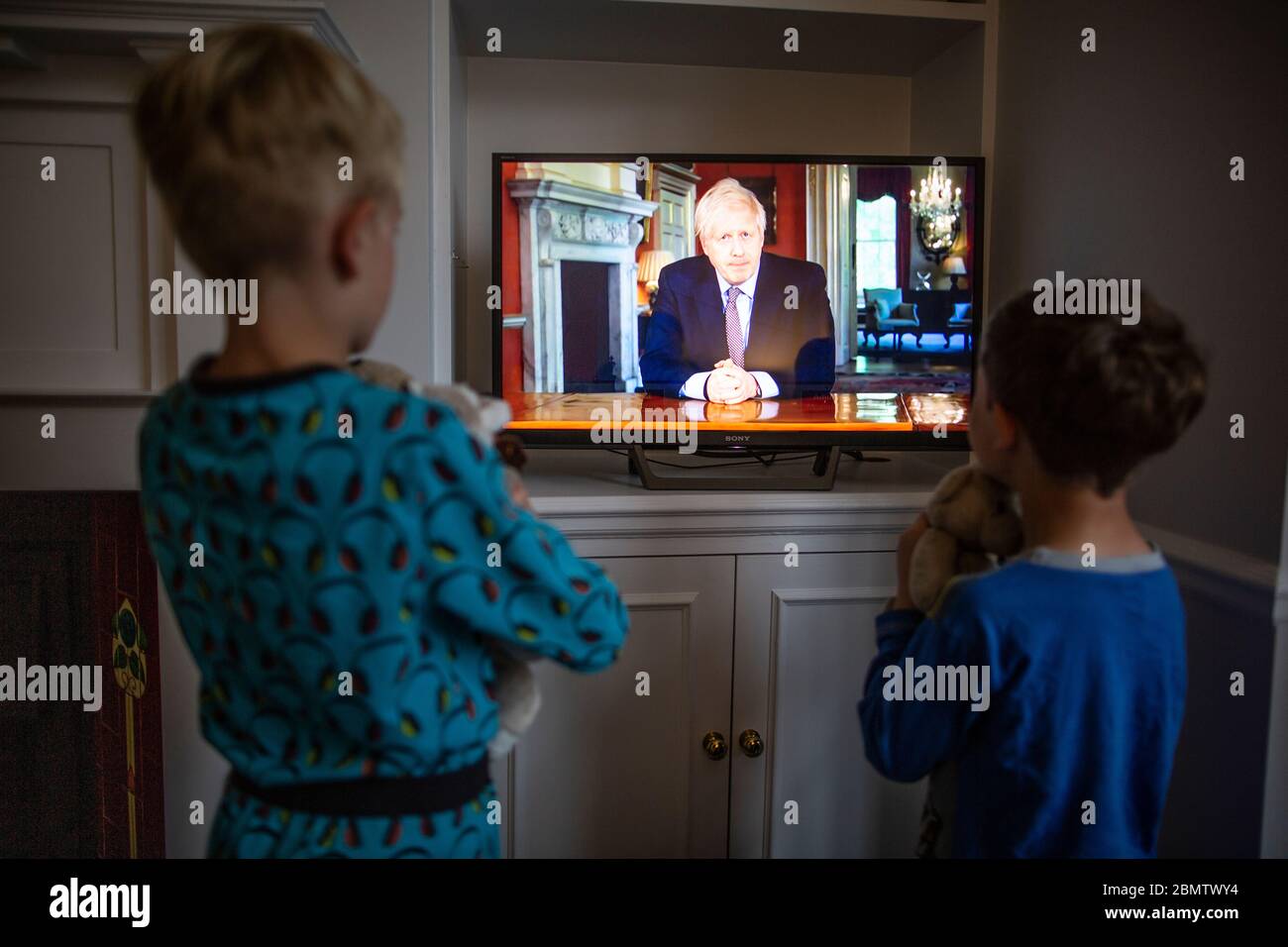 Familie beobachtet Premierminister Boris Johnson, der im nationalen Fernsehen die britische Nation anRede und die Schritte eines "Road Map" aus der Sperrung des Coronavirus aufführt Stockfoto