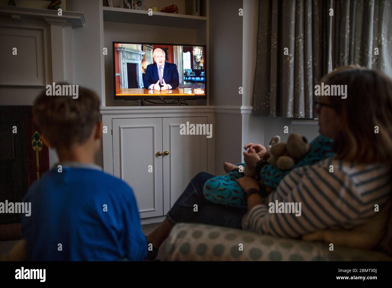 Familie beobachtet Premierminister Boris Johnson, der im nationalen Fernsehen die britische Nation anRede und die Schritte eines "Road Map" aus der Sperrung des Coronavirus aufführt Stockfoto