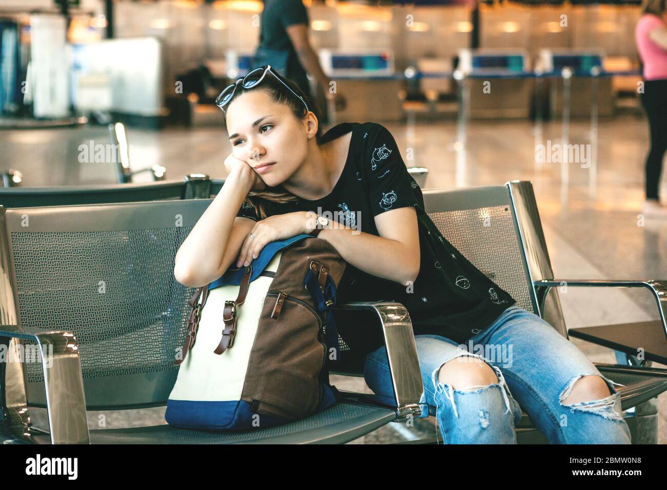 Verärgert oder gelangweilt Mädchen Touristen oder Studenten am Flughafen. Ihr Flug war verspätet oder sie war müde. Stockfoto