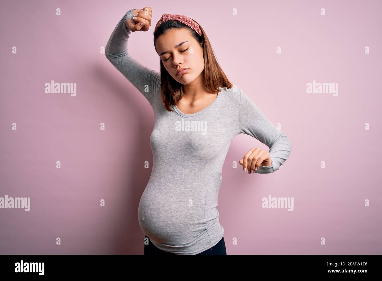 Junge schöne Teenager-Mädchen schwanger erwarten Baby über isoliert rosa Hintergrund Strecken zurück, müde und entspannt, schläfrig und Gähnen für frühe m Stockfoto