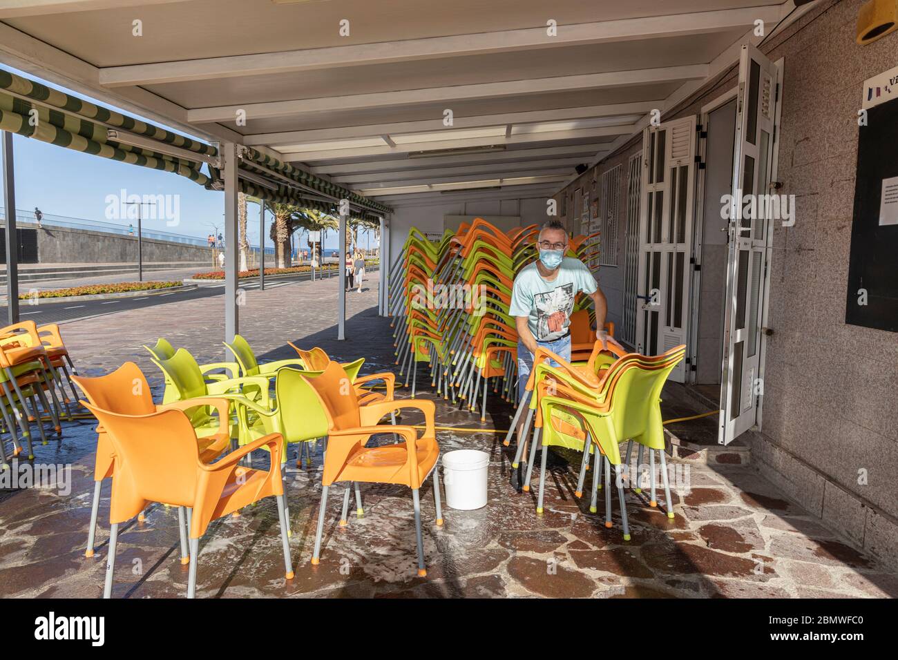In Vorbereitung auf die Eröffnung reinigt ein Barbesitzer die Terrassenmöbel vor Phase 1 der Deeskalation des Covid 19 State of Emergency Lock down, Playa San Stockfoto