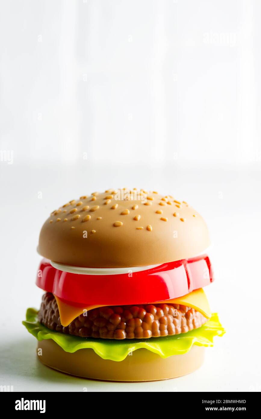 Kreatives Burger-Spielzeug aus Kunststoff mit Salat, Tomaten und  Rindfleisch auf hellgrauem Hintergrund. Konzept der schädlichen künstlichen  Lebensmitteln. Nicht biologisch. Nicht nützlich Stockfotografie - Alamy