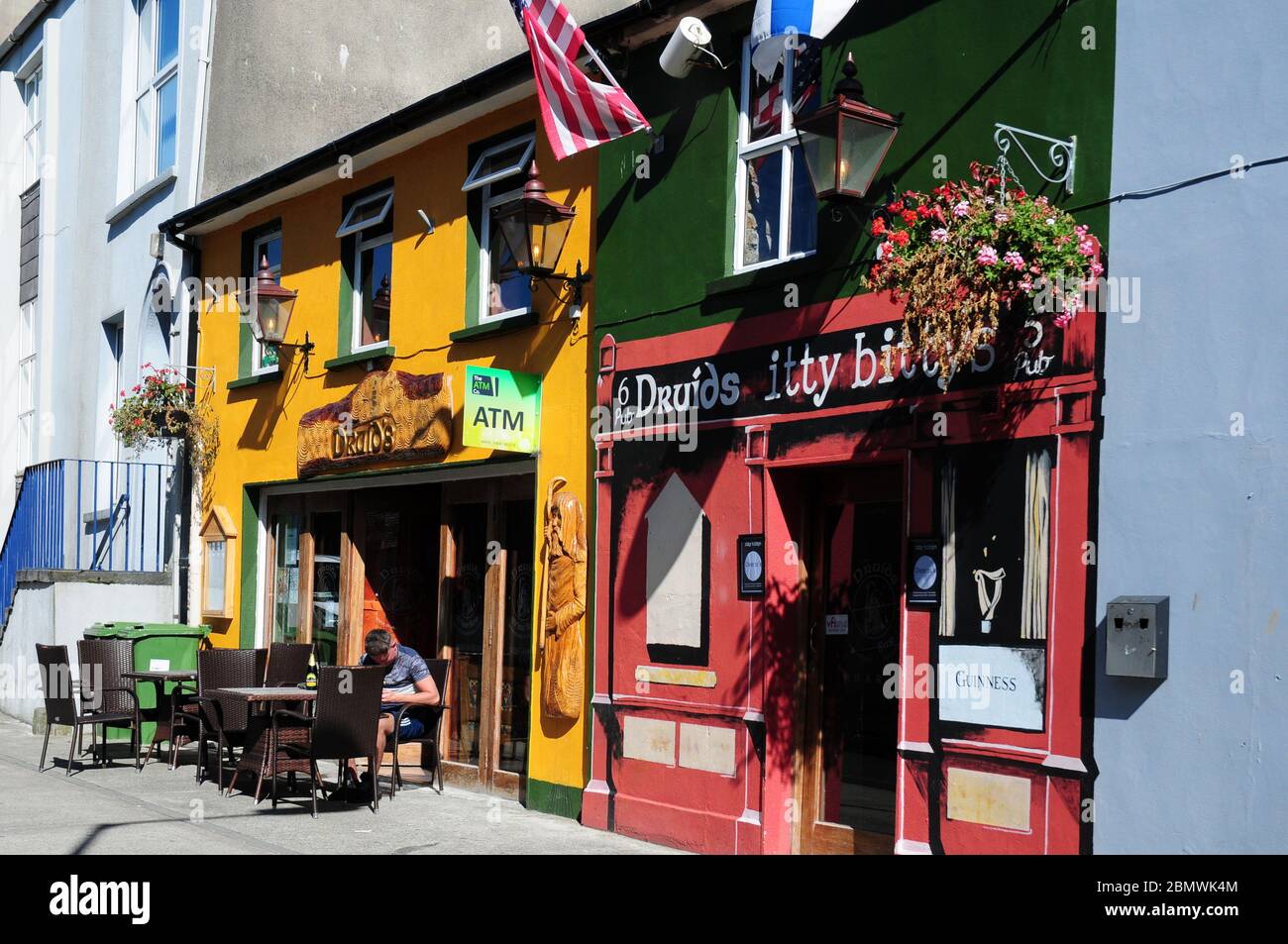 Mann sitzt an Tisch und Stühlen im Café in WaterfordDungarvan, Irland. Stockfoto