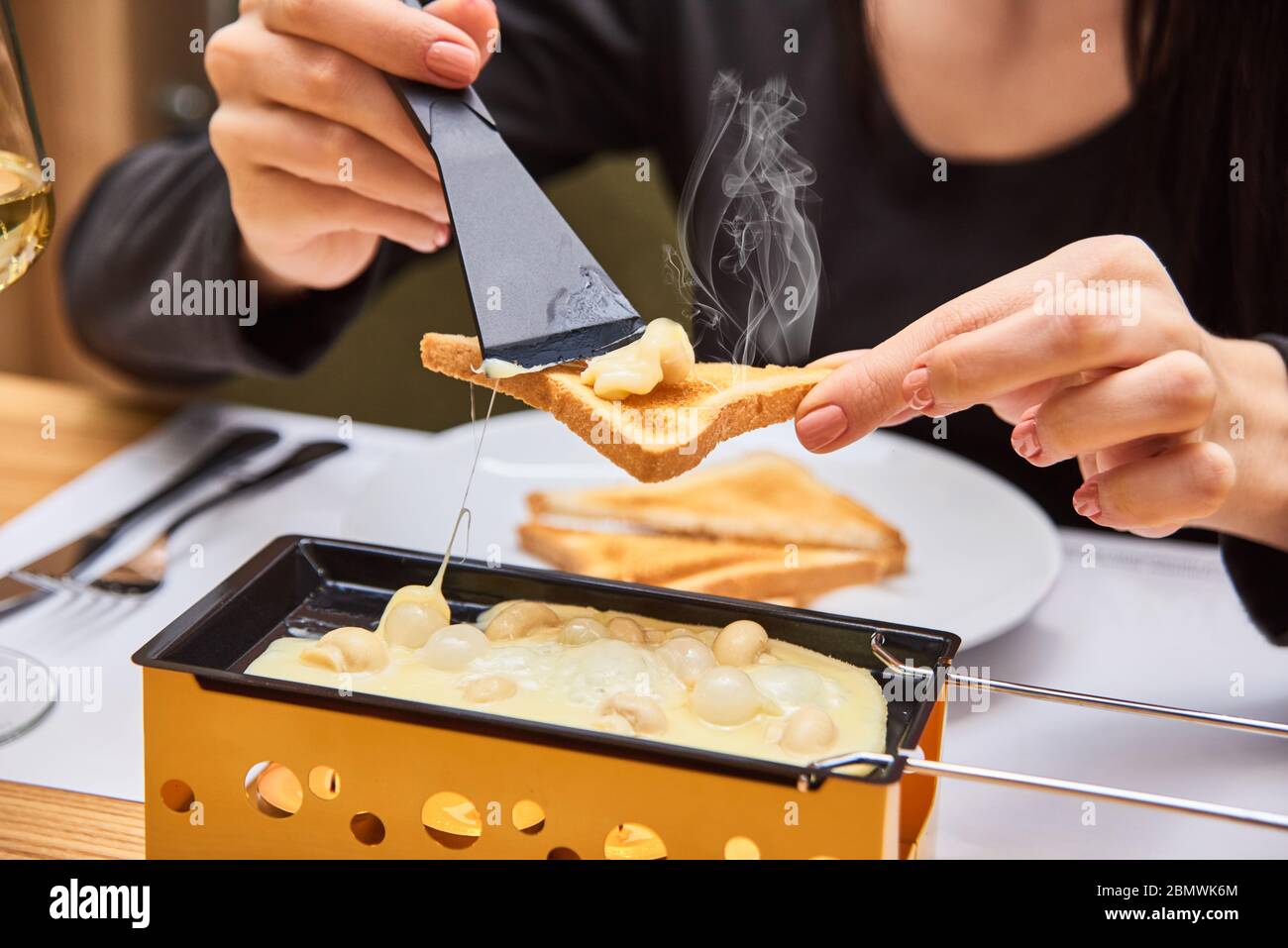 schweizer Küche. Käse Raclette mit Pilzen auf Coupéllen - spezielle ...