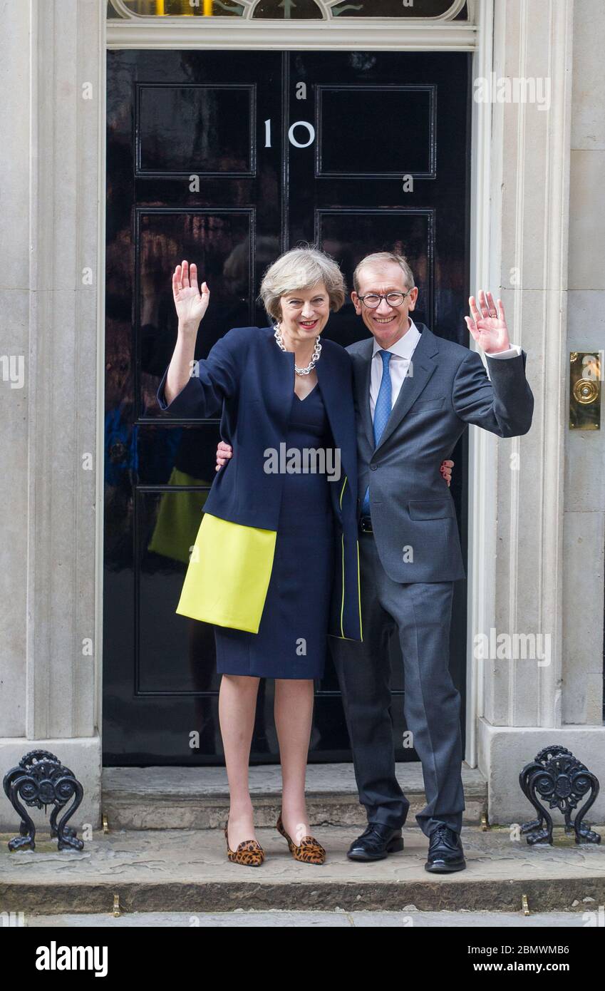 Premierministerin Theresa May und ihr Mann Philip winkt an ihrem ersten Arbeitstag für die zusammengebauten Kameras außerhalb der Downing Street 10. 13. J Stockfoto