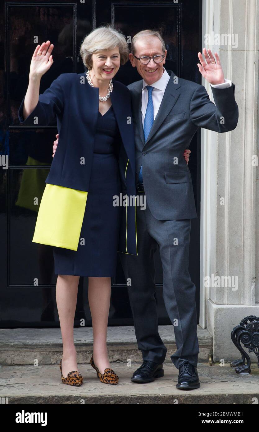 Premierministerin Theresa May und ihr Mann Philip winkt an ihrem ersten Arbeitstag für die zusammengebauten Kameras außerhalb der Downing Street 10. 13. J Stockfoto