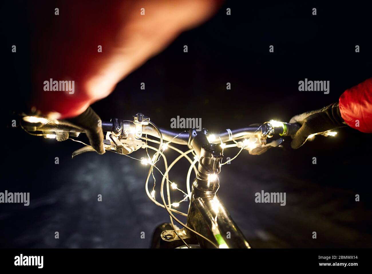 Mountainbike Lenker mit Weihnachtsbeleuchtung im Schnee Straße im Winter Nacht eingerichtet Stockfoto