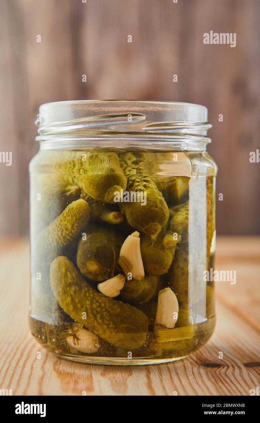 Fermentierte konservierte vegetarische Küche Konzept. Gurken in einem Glas auf einem hölzernen Küchentisch. Das Konzept der Konserven. Kopierbereich Stockfoto