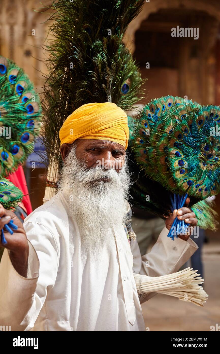 JAISALMER, INDIEN - 14. MÄRZ 2015: Alte Menschen in der Gelben Turbane verkauft Pfauenfedern in Jaisalmer, Indien. Jaisalmer ist eine sehr beliebte touristische Bestimmungen Stockfoto