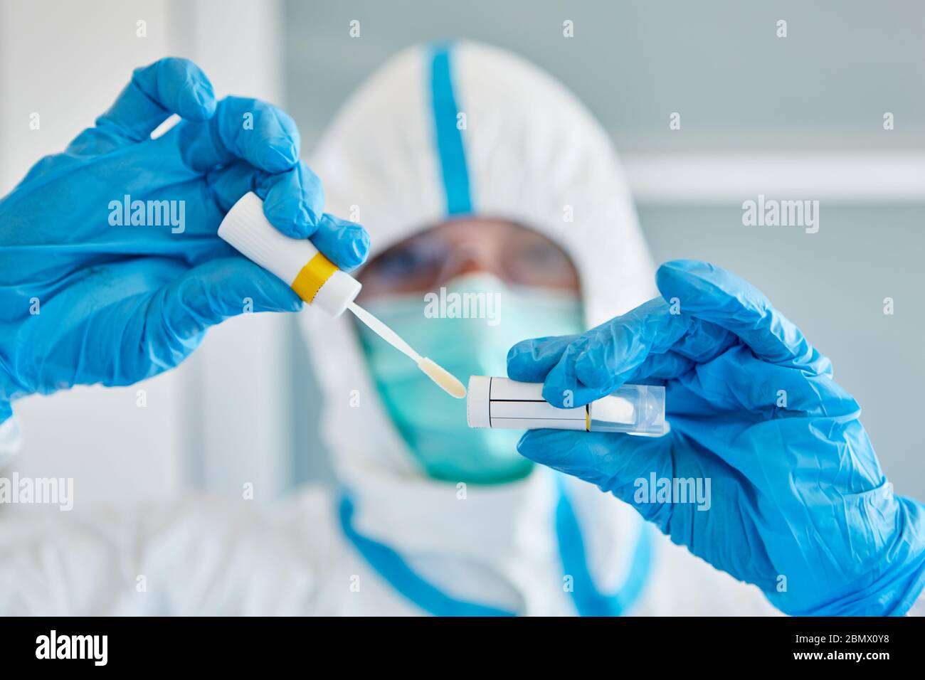 Medic in Schutzkleidung mit Rachenabstrich während Speichelprobe für Coronavirus-Test Stockfoto