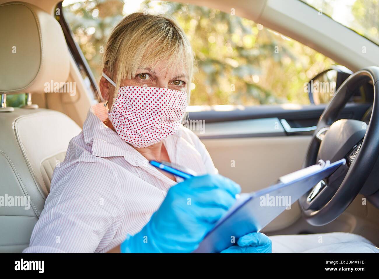 Besucher des Pflegeheims mit Gesichtsmaske melden sich an, um die Kontaktliste für die Coronavirus-Pandemie zu kontaktieren Stockfoto