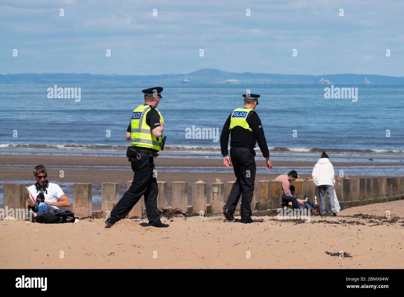 Portobello, Schottland, Großbritannien. 11 Mai 2020. Polizei patrouilliert Promenade und Strand in Portobello heute Nachmittag bei warmem, sonnigem Wetter. Sie sprachen mit der Öffentlichkeit, die am Strand oder an der Meeresmauer saßen und baten sie, sich weiter zu bewegen. Iain Masterton/Alamy Live News Stockfoto