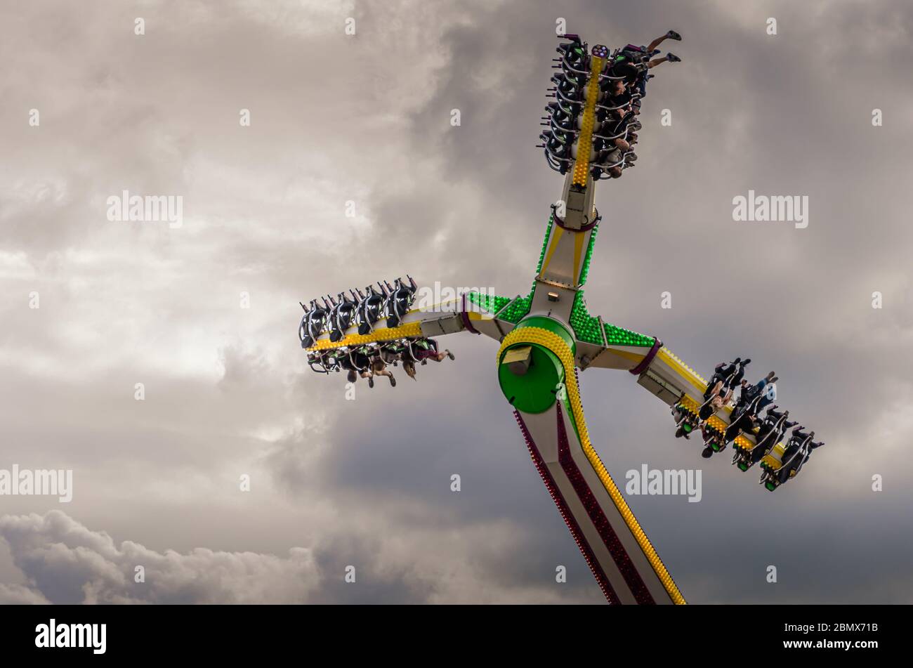 Blick auf Nervenkitzel auf einem Fairground Fahrt gegen einen dramatischen bewölkten Himmel Stockfoto