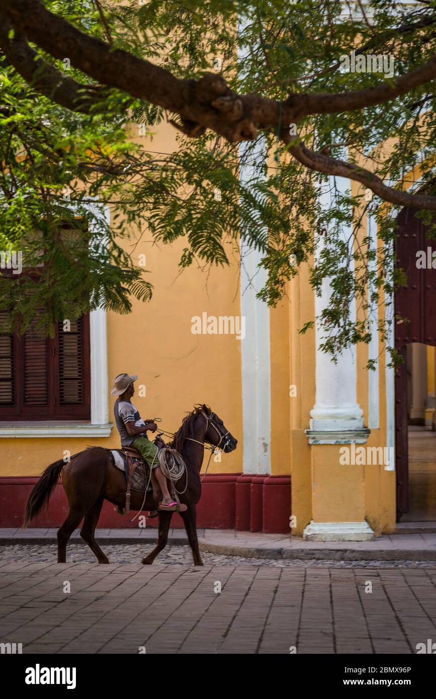Mann, der ein Pferd in der Kolonialzeit Zentrum der Stadt, Trinidad, Kuba reitet Stockfoto