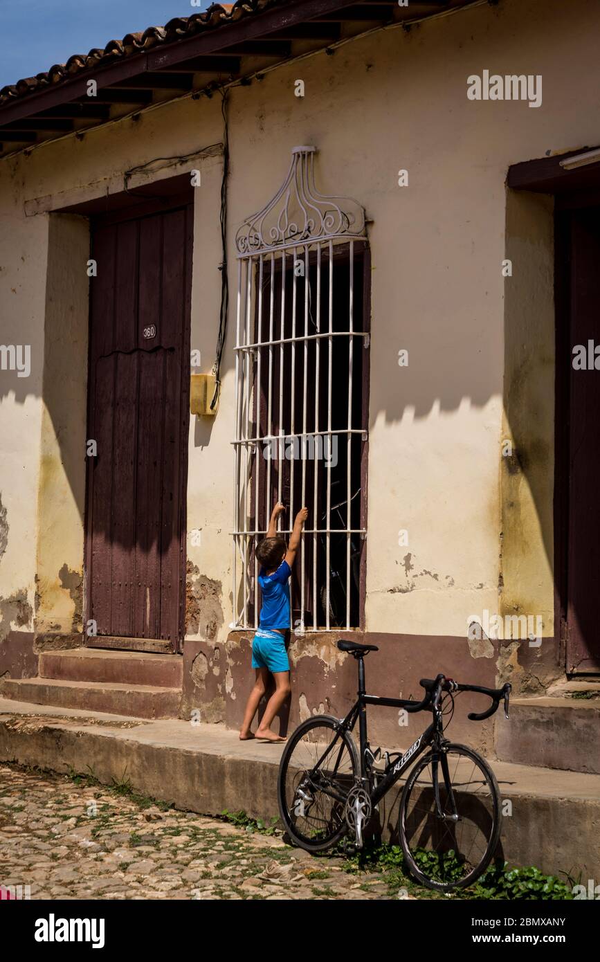Straßenszene mit einem Jungen und einem Fahrrad im alten Kolonialzentrum der Stadt, Trinidad, Kuba Stockfoto