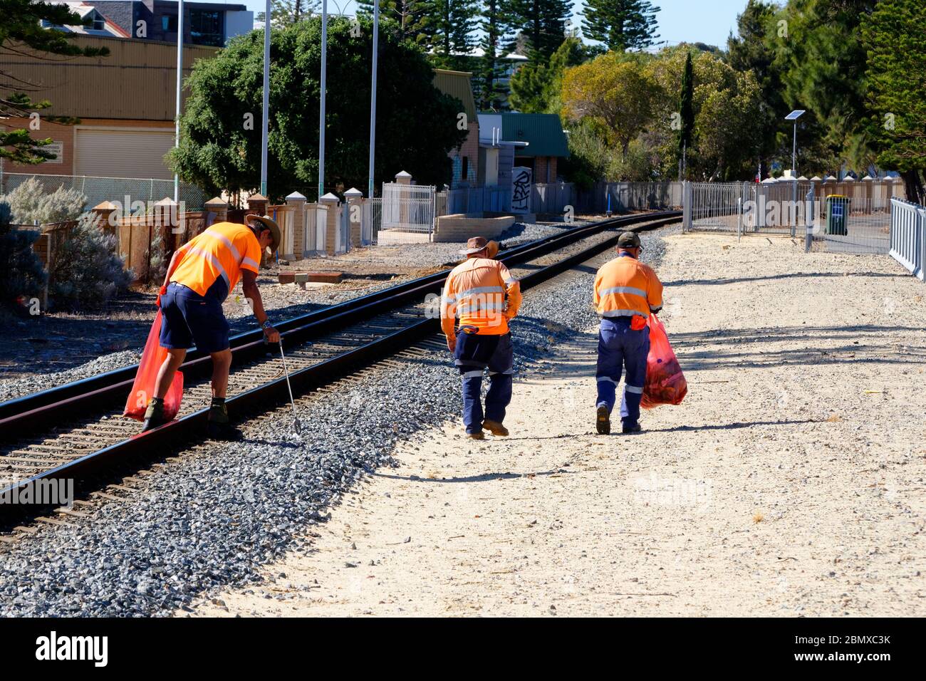 Arbeitsgruppe von 3 Männern, die Müll von der Eisenbahnlinie, Fremantle, Westaustralien entfernen Stockfoto