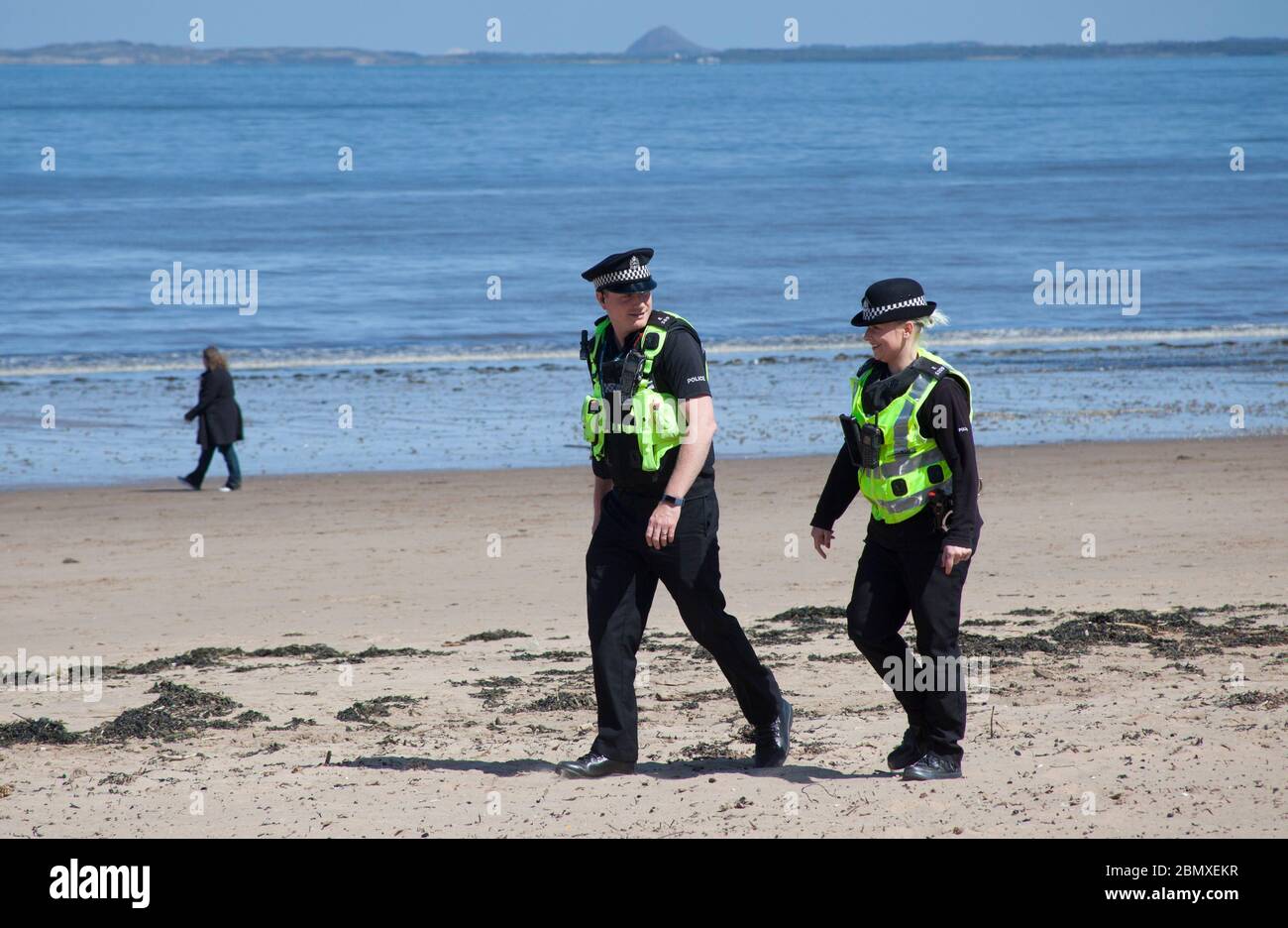 Portobello Beach, Edinburgh, Schottland, Großbritannien.11. Mai 2020. Polizeipatrouille von vier freundlichen Beamten drei männlich und ein weiblich an der ziemlich ruhigen Küste, Wir haben uns mit den wenigen Leuten, die sich am Sandstrand oder an der Promenade hinsetzten, gechattet und ihnen empfohlen, das Coronavirus von Oberflächen zu ziehen, die sie berühren, während sie am Meer sind, und ihnen zu raten, sich zu bewegen und ihre erlaubte Bewegung zu nehmen, während sie unterwegs sind. Quelle: Arch White / Alamy Live News Stockfoto