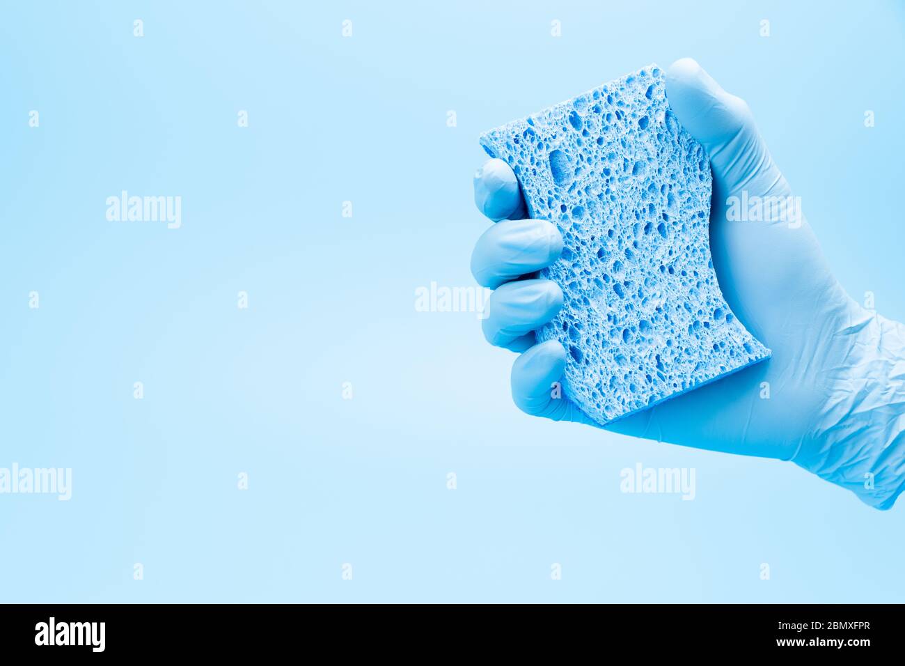 Hand in blauen Handschuh mit Schwamm Stockfoto