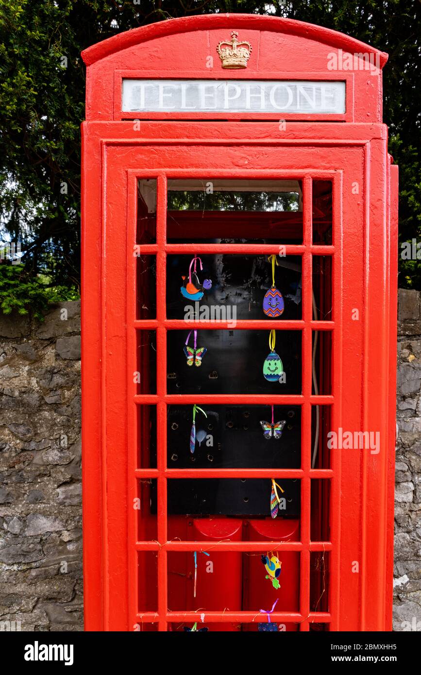 K6 rote Telefonbox in einer ruhigen Gegend von Bristol UK ohne Glas, aber mit bunten Keramikkugeln dekoriert Stockfoto