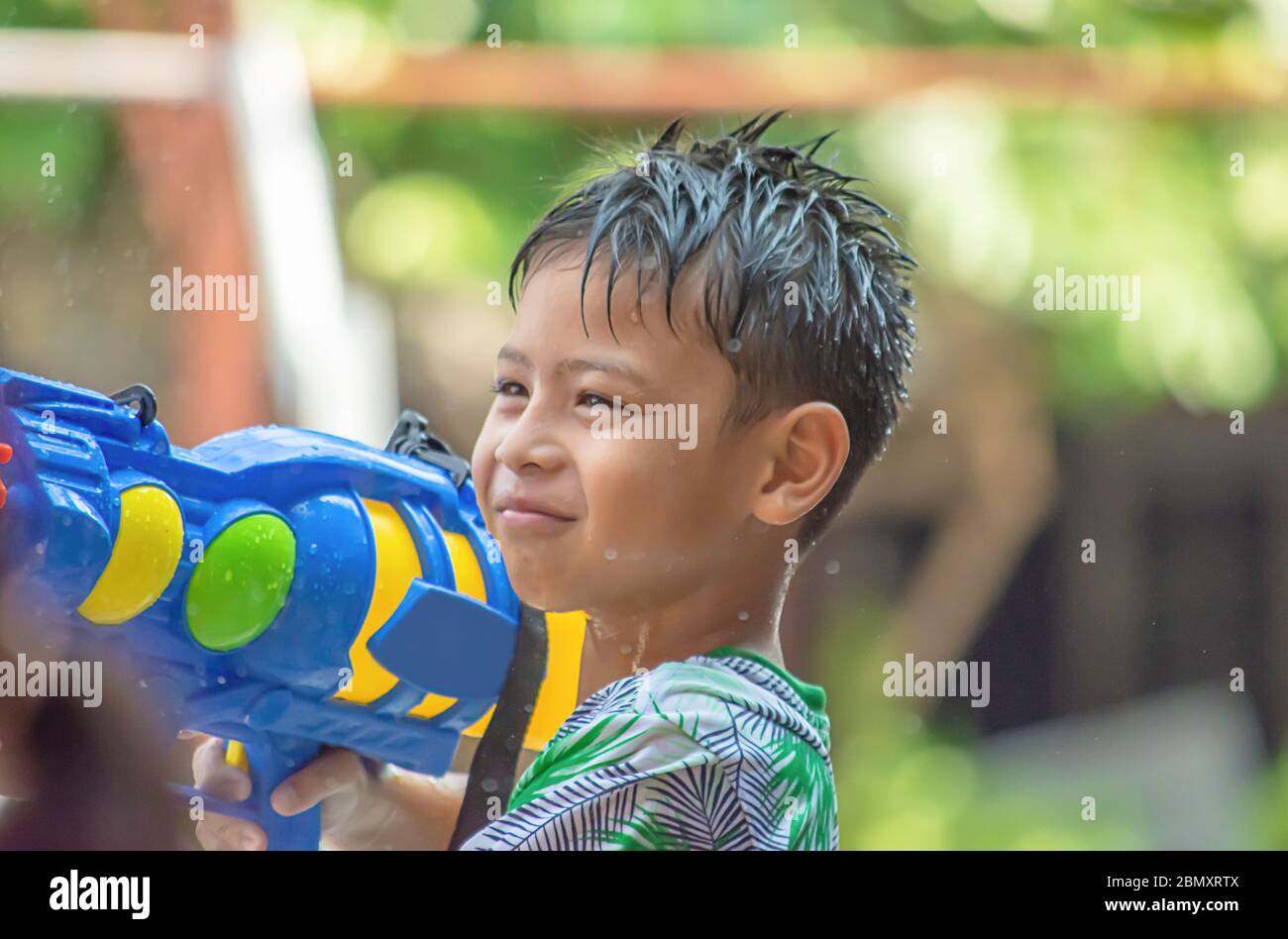 Asian Boy Holding eine Wasserpistole spielen Songkran Festival oder Thai Neujahr in Thailand. Stockfoto