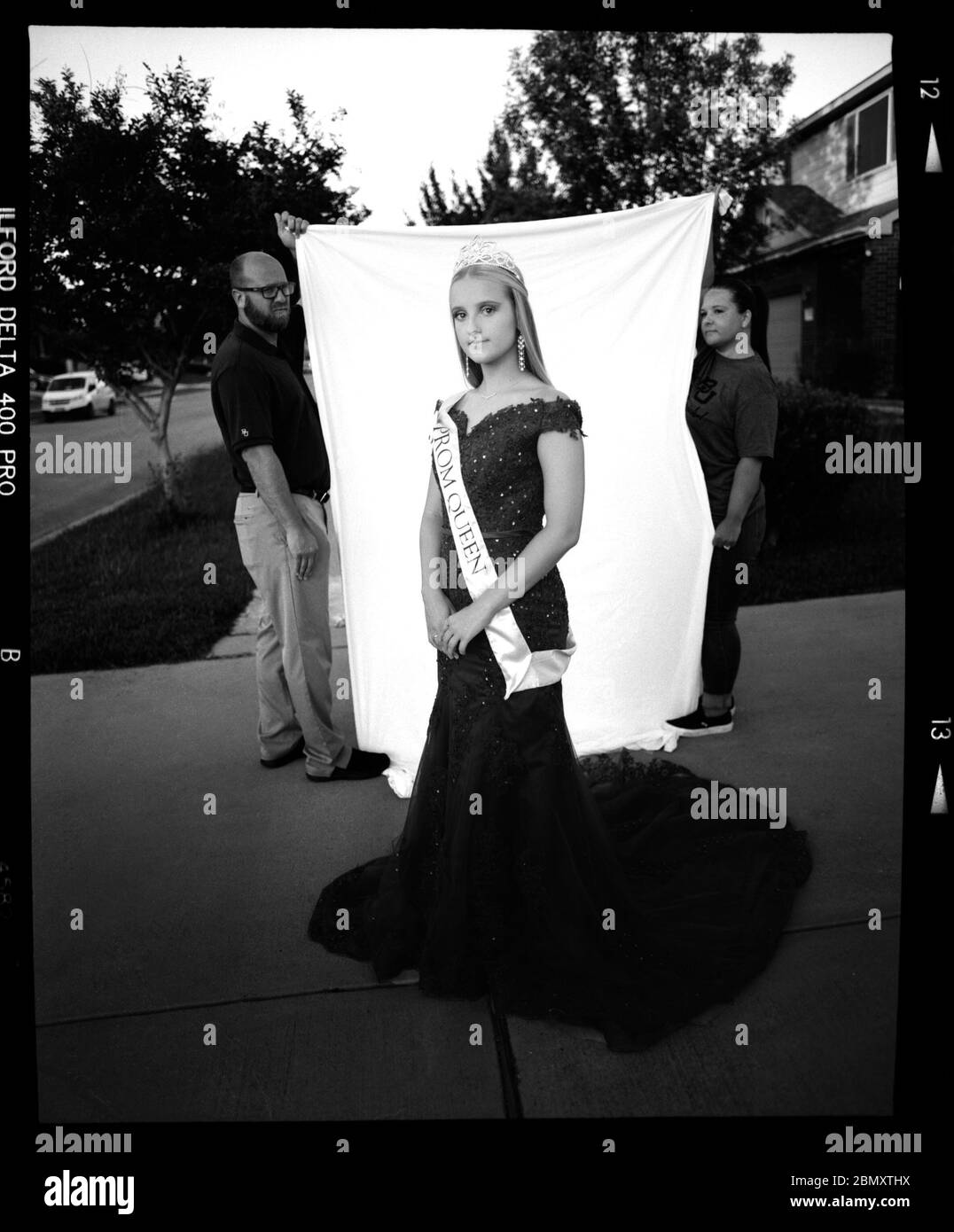 Killeen, Texas, USA. Mai 2020. FAITH DEARING, 18, trägt die Abschlussball-Königin ihrer Schwester mit dem Kleid, das sie zum Abschlussball tragen wollte, bevor es aufgrund von COVID-19 Bedenken abgesagt wurde. Ihre Mutter und ihr Vater haben eine Kulisse hinter sich. "Zwei Jahre lang wartete ich darauf, dass die Abschlussball-Königin das erfüllte, was meine Schwester tat, als sie in der High School war, aber jetzt werde ich es nicht mehr können", sagte Dearing. Kredit: Christian K. Lee/ZUMA Wire/Alamy Live News Stockfoto