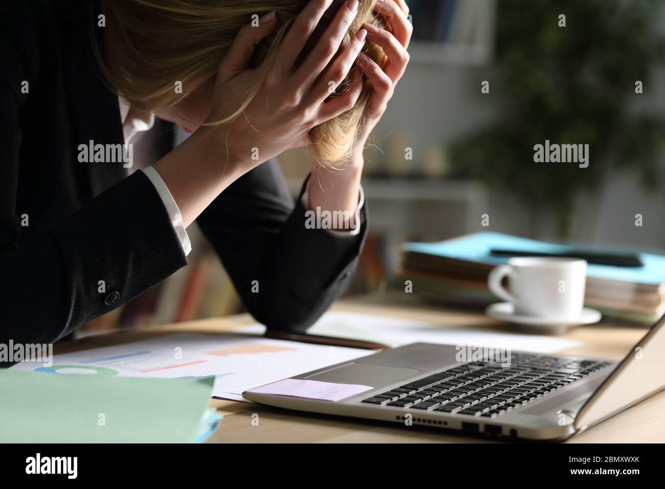 Nahaufnahme der traurigen Unternehmerin, die sich nachts über schlechte Ergebnisse auf einem Schreibtisch zu Hause beschwert Stockfoto