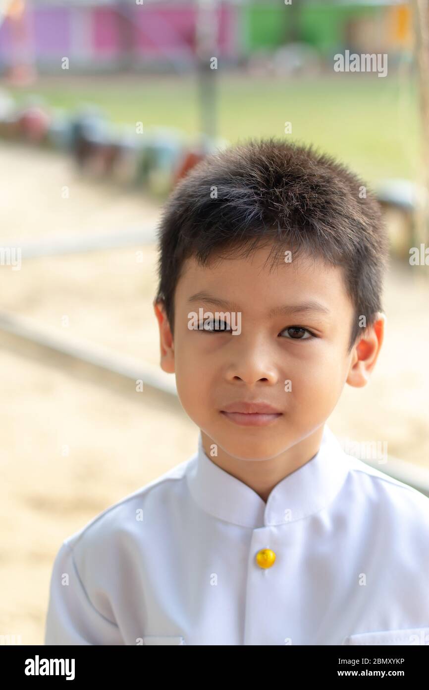 Porträt des asiatischen Jungen trägt ein weißes Hemd im Gras. Stockfoto