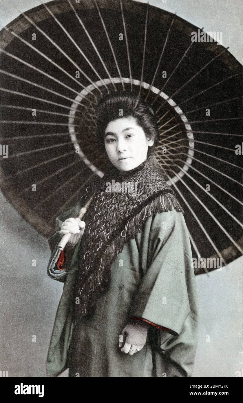 [ 1910er Japan - Japanische Frau mit Sonnenschirm ] - Japanische Frau in Winterkleidung mit Papierschirm. Sie trägt einen Michiyuki-Mantel (道行コート). Vintage-Postkarte des 20. Jahrhunderts. Stockfoto