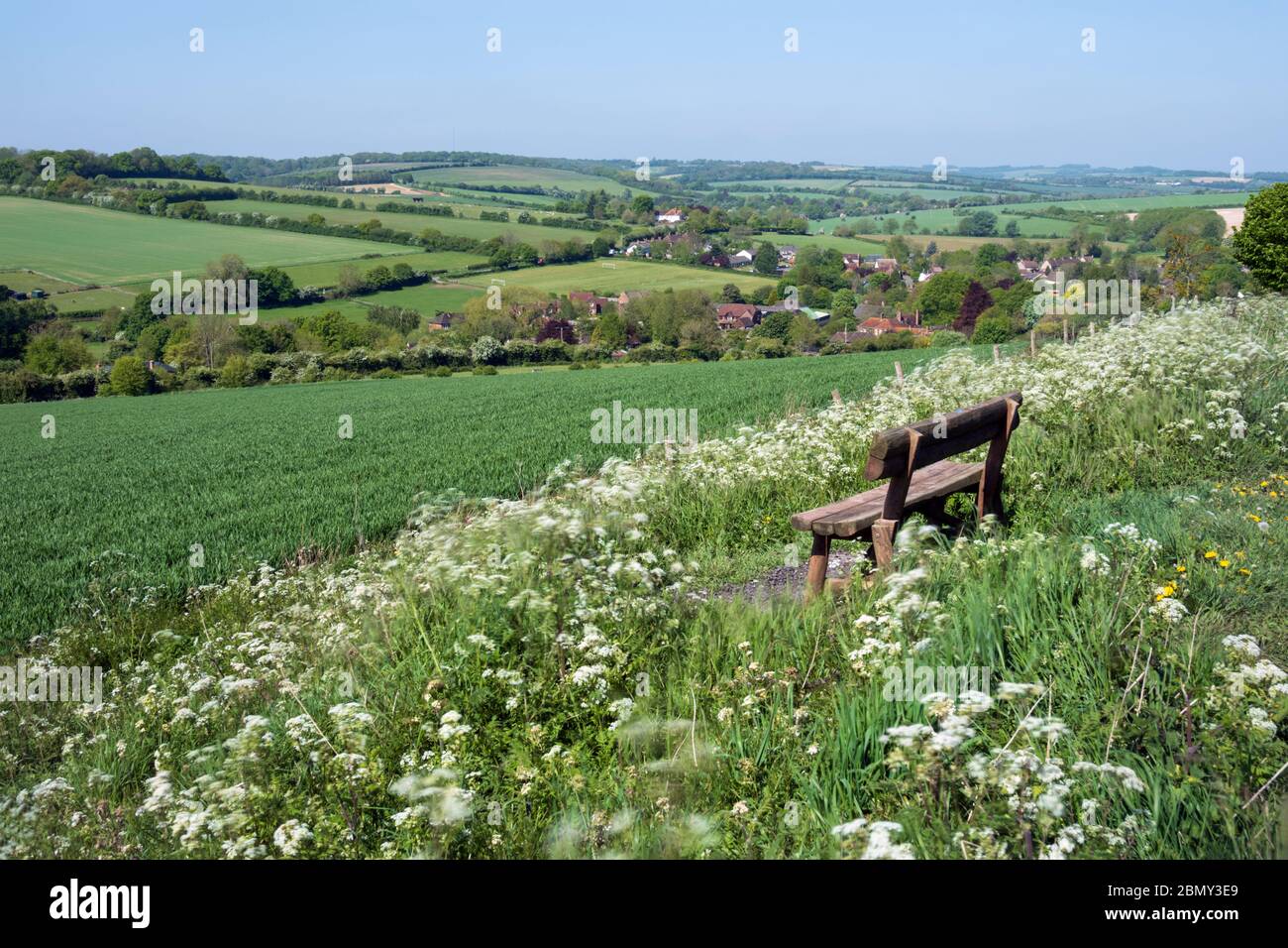 Holzbank mit Blick auf das Dorf East Garston und das Lambourn Valley, East Garston, West Berkshire, England, Großbritannien, Europa Stockfoto