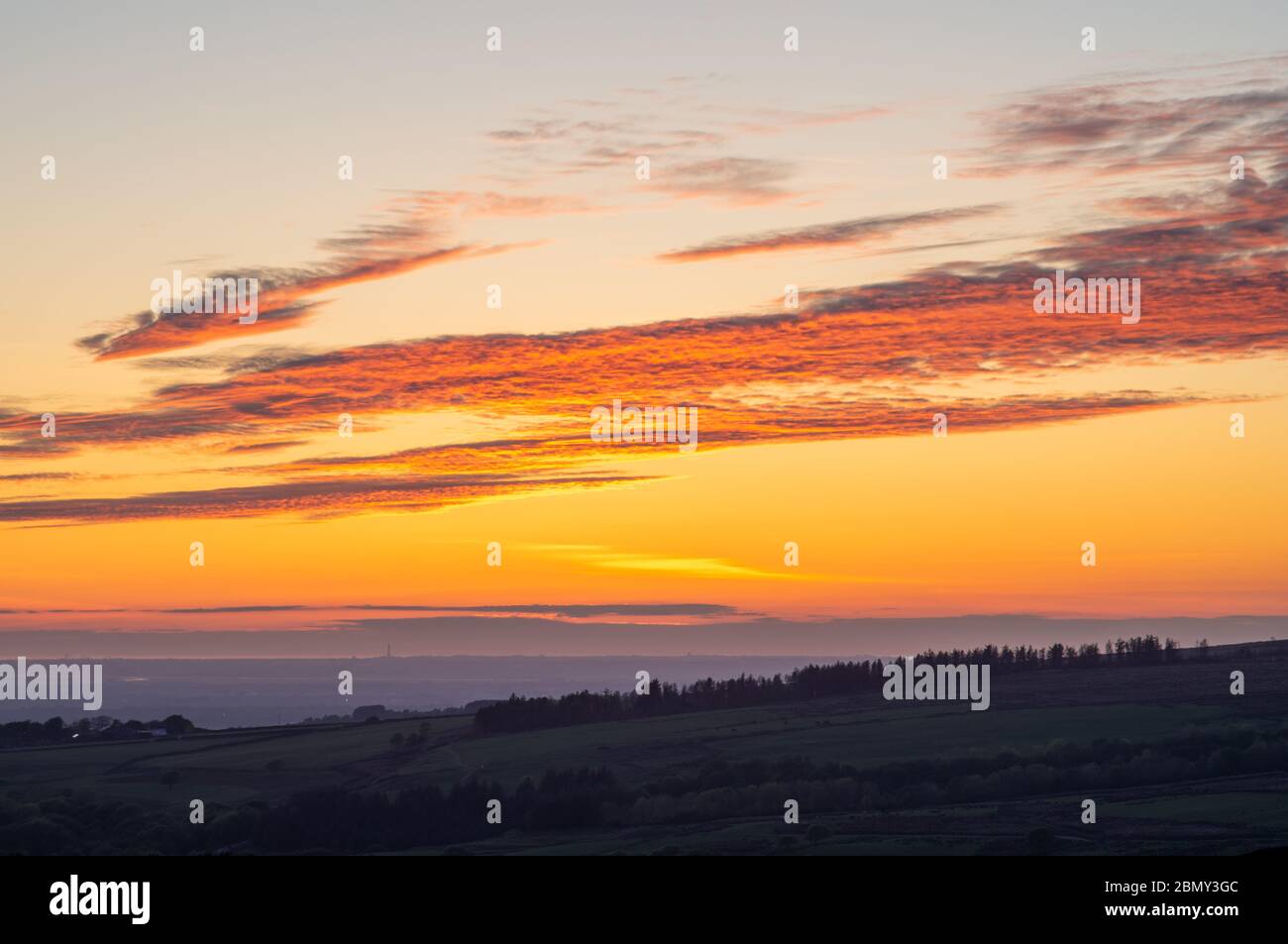 Sonnenuntergang von Rivington, Chorley mit der Silhouette des Blackpool Tower und dem Pleasure Beach am Horizont, etwa 25 Meilen entfernt. Stockfoto