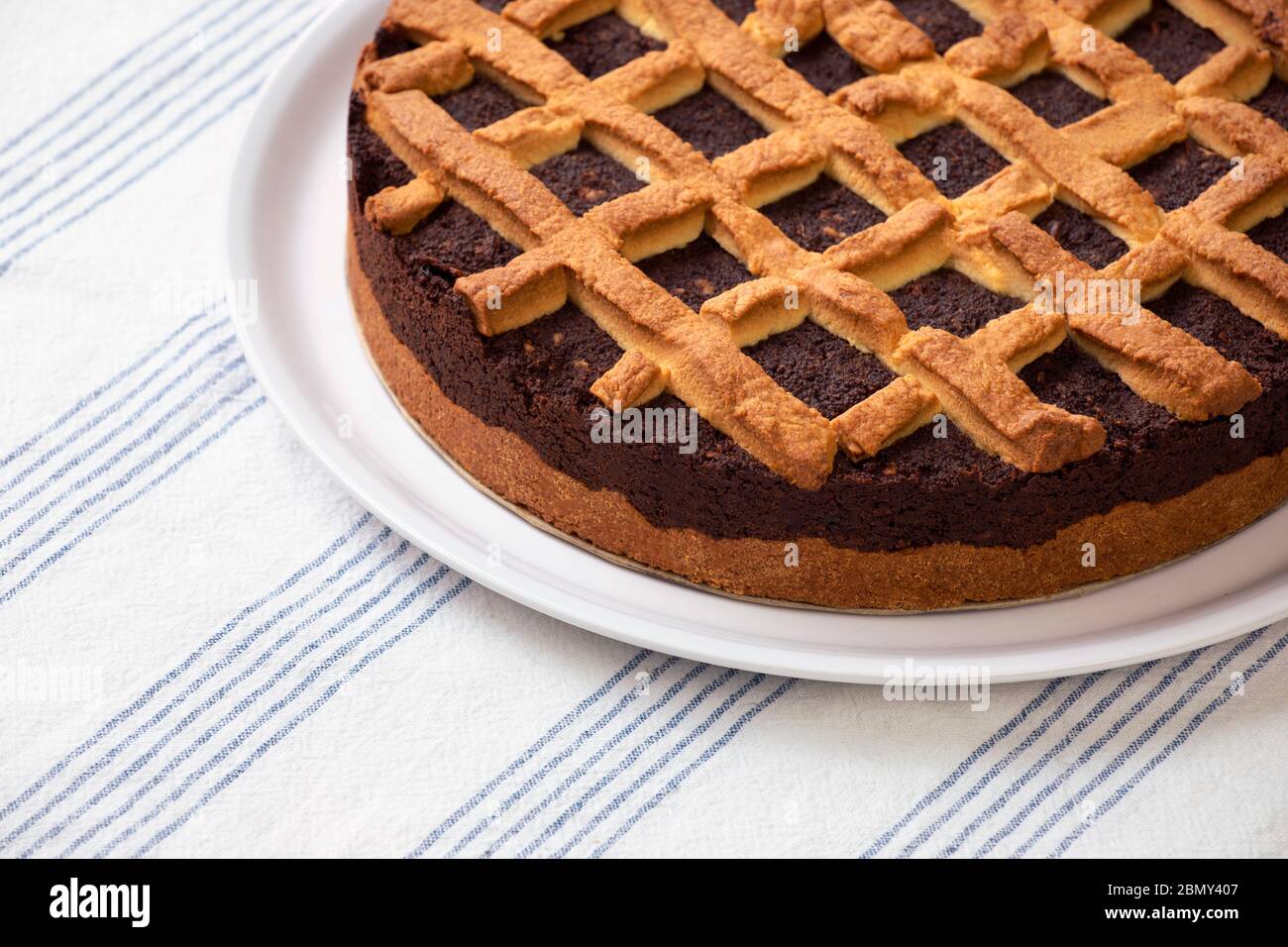 Nahaufnahme von frischem Mohn auf dem Teller serviert. Hausgemachte Mohn-Kuchen legen auf einem Tisch mit Tischdecke. Runde, frische Torte, fertig zum Essen. Stockfoto