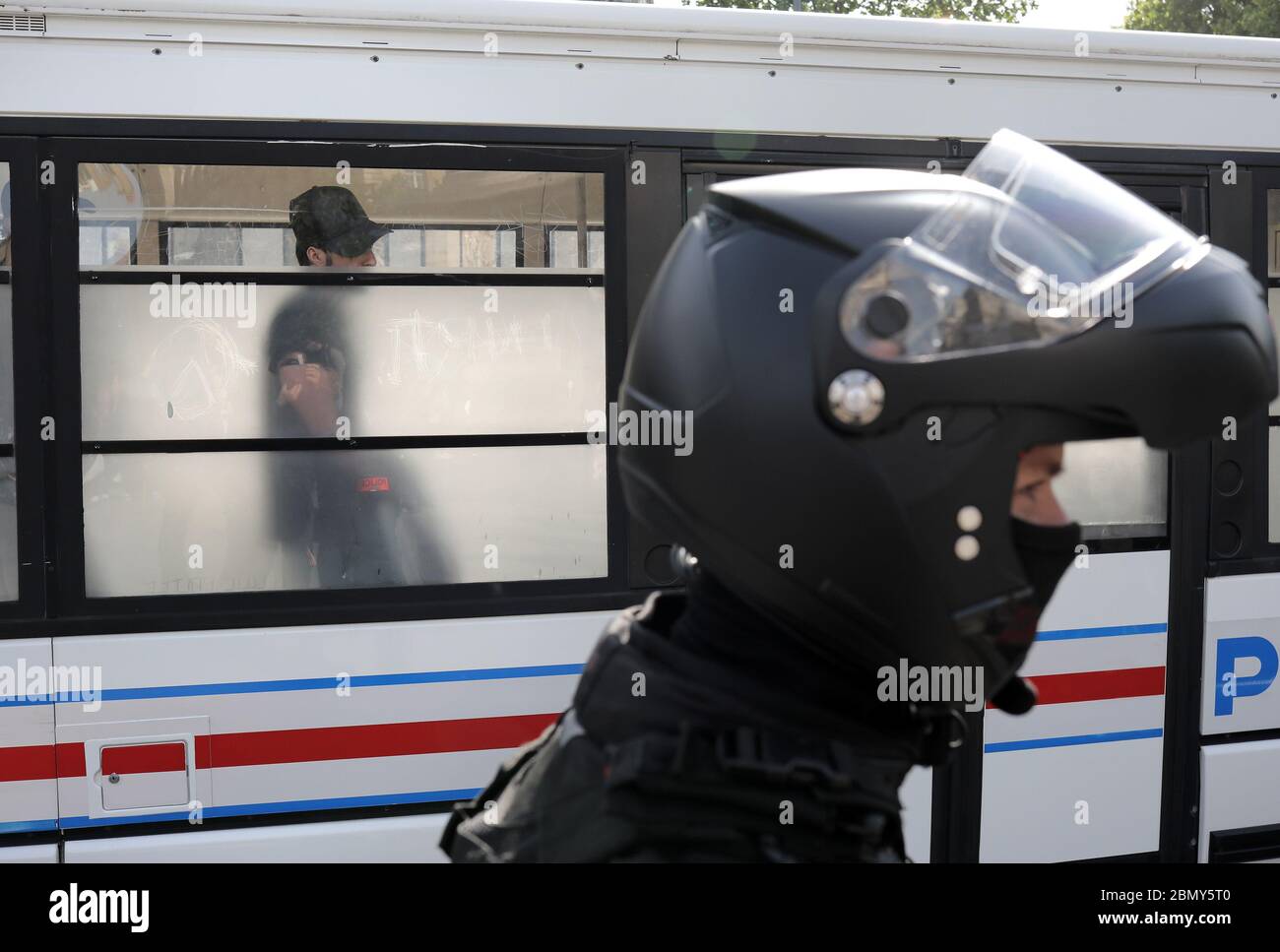 Paris, Frankreich. Mai 2020. Ein verhaftete regierungsfeindliche Protestierende schaut aus dem Polizeiwagen, als ein französischer Sicherheitsmann mit einer Schutzmaske gegen Covid-19 Wache hält, nachdem Aktivisten der Gelbwesten am Montag, den 11. Mai 2020, auf dem Platz der Republik in Paris, Frankreich, zu versammeln versuchten. Die französischen Behörden haben heute damit begonnen, die Sperrung von Covid-19 aufzuheben, aber die Menschen, die in den am stärksten gefährdeten Regionen leben, insbesondere in Paris, sind nach wie vor strengen Beschränkungen ausgesetzt. Foto von Eco Clement/UPI Quelle: UPI/Alamy Live News Stockfoto