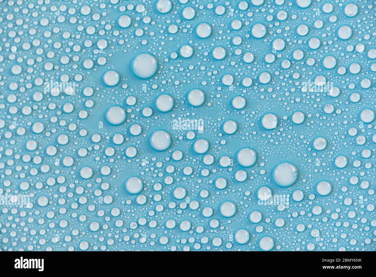Nahaufnahme von Wassertropfen auf blauer Oberfläche, Regentropfen, Hintergrund oder Textur Stockfoto