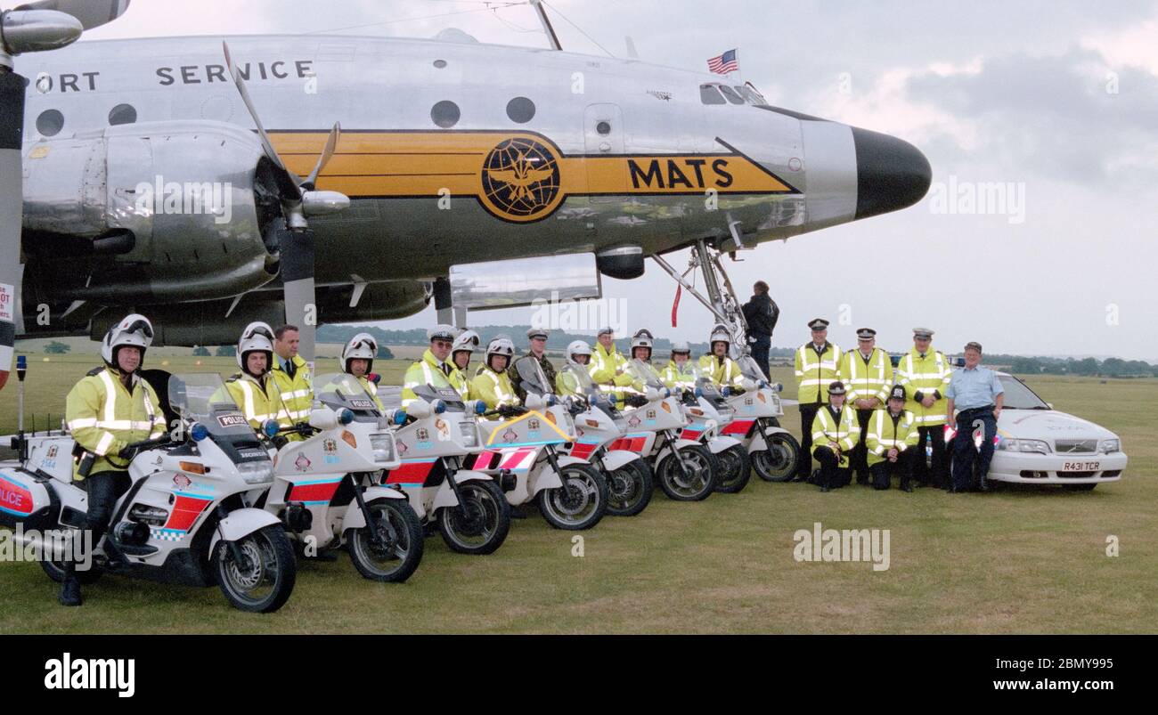 Polizeibeamte der Hampshire Constabulary Traffic Division, die die Straßen für die Middle Wallop Air Show überwachen, posieren für ein Gruppenfoto mit einem Lockheed C-121A Constellation Aircraft - Middle Wallop, Hampshire, England, UK - Juni1998. Stockfoto
