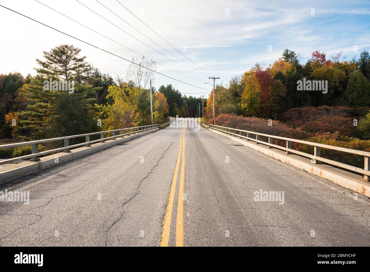 Verlassene Brücke entlang einer Forststraße im Herbst auf dem Land. Wunderschöne Herbstfarben. Stockfoto