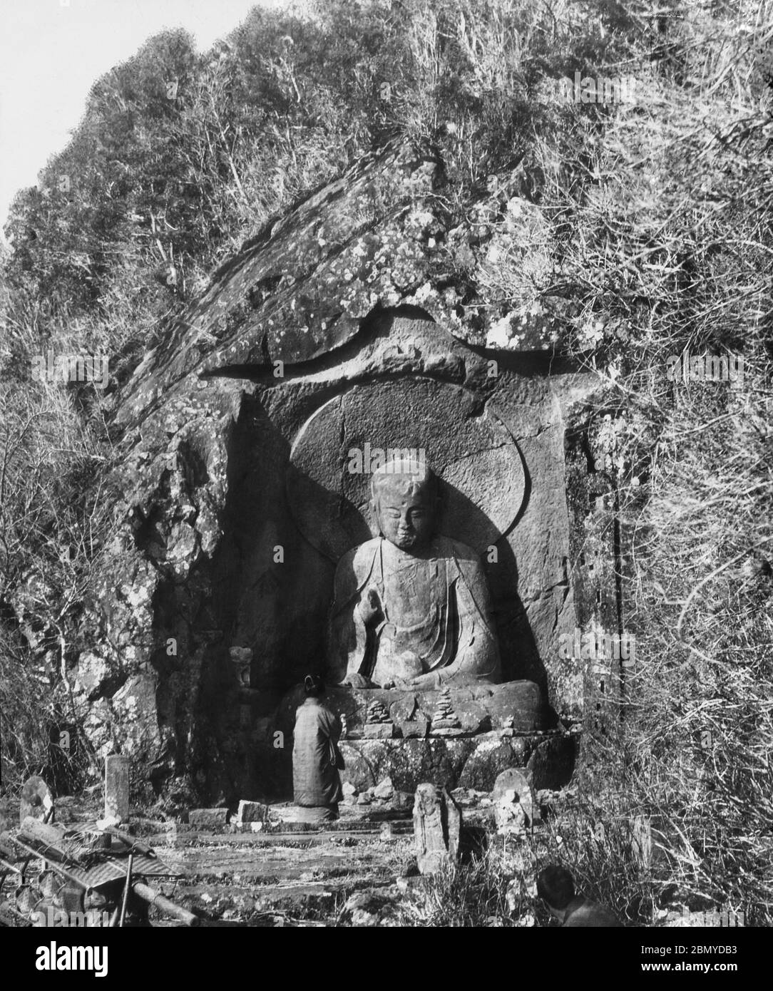 [ 1890er Jahre Japan - Japanische Buddhistische Statue ] - Beten an einer Statue der buddhistischen Gottheit Jizo in Hakone, Präfektur Kanagawa. Bekannt als Rokudo Jizo (六道地蔵), ist es eine 3.5 Meter hohe Buddha-Figur, die auf einer Felswand geschnitzt wurde und aus der Kamakura-Zeit (1185-1333) stammt. Aus einer Serie von Glasdias, die vom schottischen Fotografen George Washington Wilson (1823–1893) veröffentlicht (aber nicht fotografiert) wurden. Wilsons Firma war einer der größten Verleger von Fotodrucken in der Welt. 19. Jahrhundert Vintage Glas Rutsche. Stockfoto