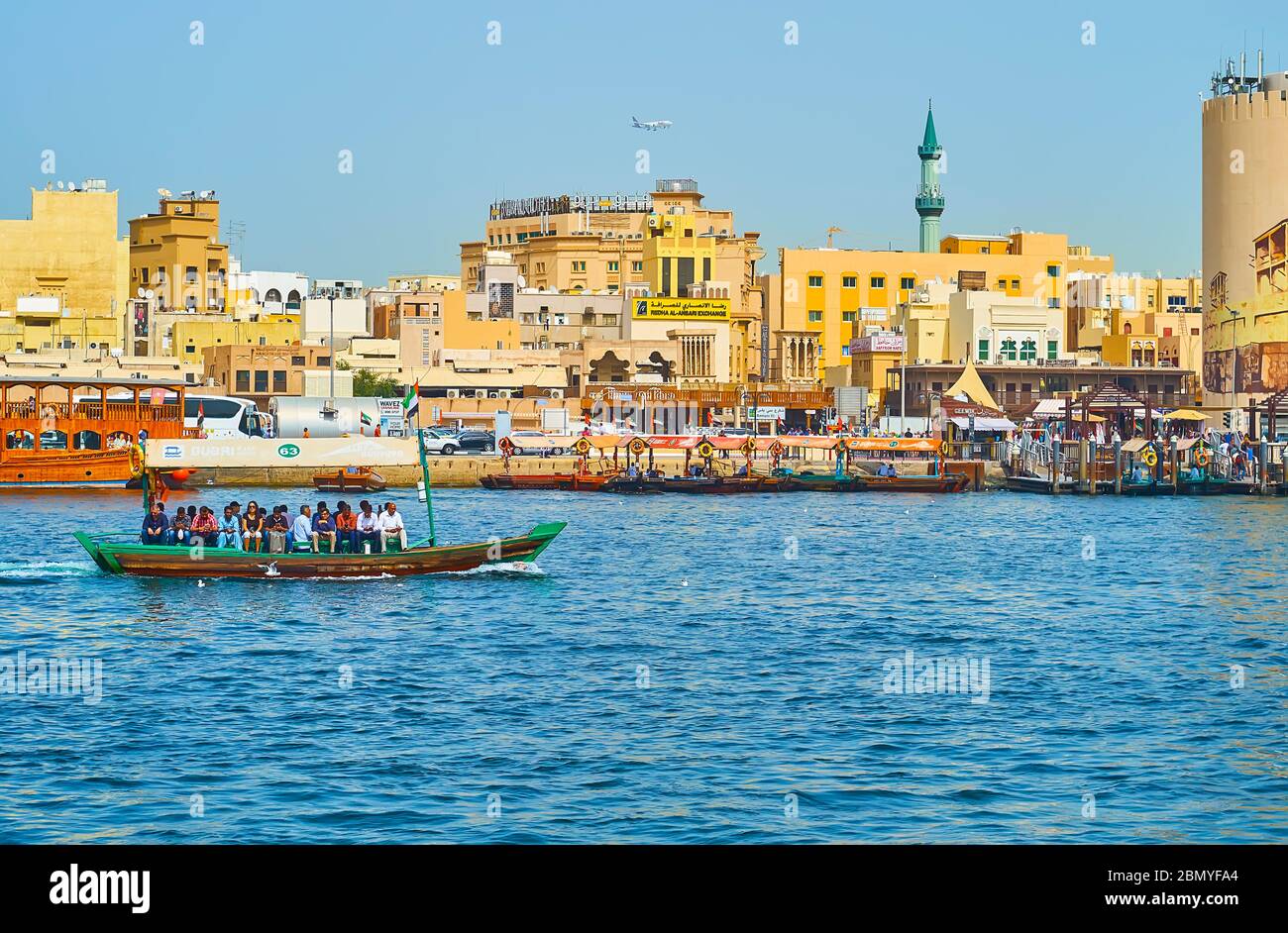 DUBAI, VAE - 2. MÄRZ 2020: Böschung des Bur Dubai District überblickt Dubai Creek mit vielen Abra Boote, Dhow Kreuzfahrten und Deira Old Souk, auf der gesehen Stockfoto