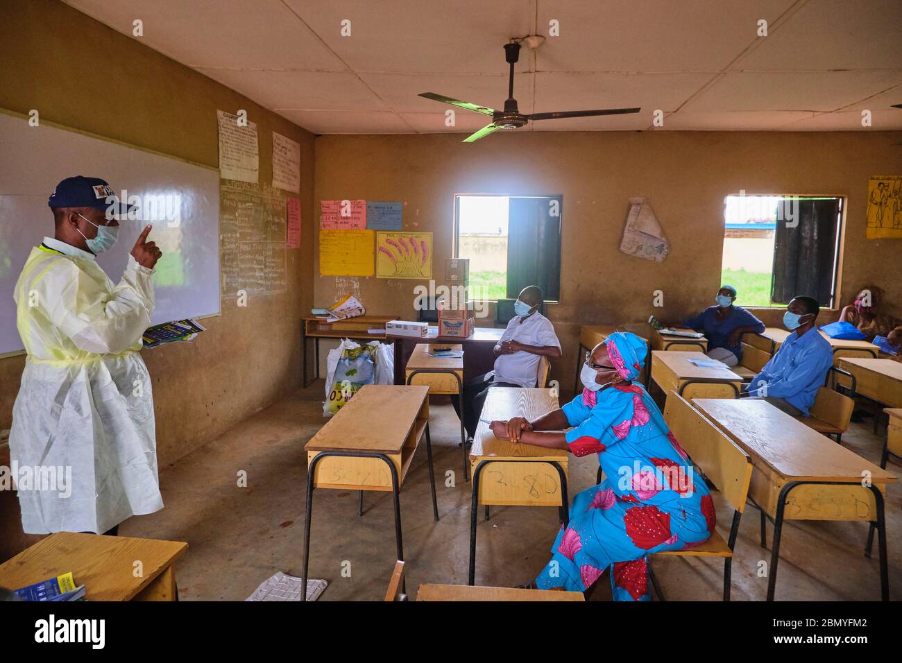 Lehrer, die PSA tragen, lehren Menschen, Gesichtsmasken an einem Programm für soziale Distanzierung zu tragen, das von einer Regierungsbehörde in Lagos, Nigeria, abgehalten wird. Stockfoto