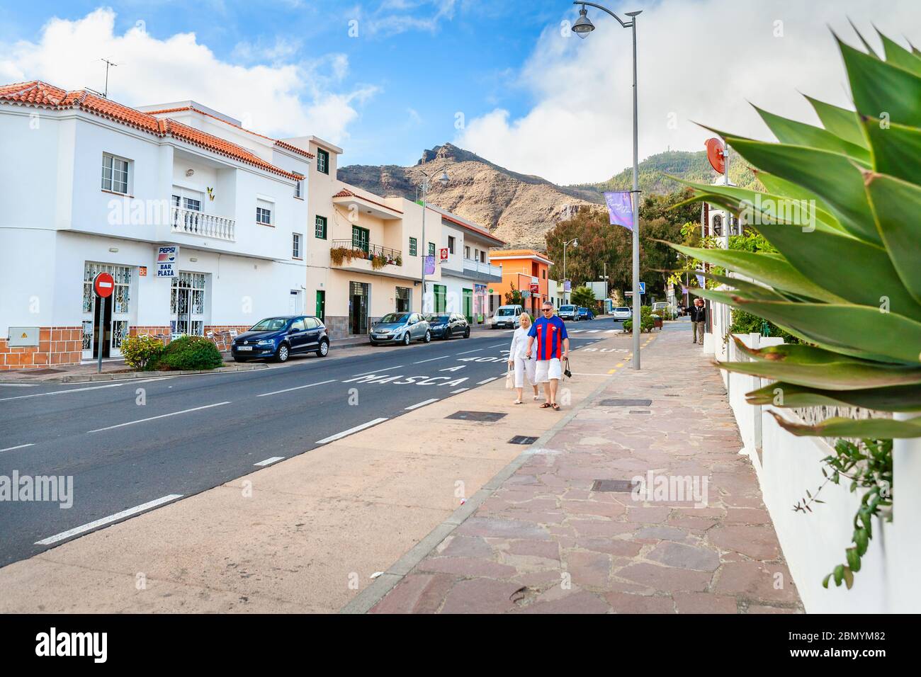 Touristen gehen entlang der Iglesia Avenue in der Altstadt von Santiago del Teide. Teneriffa, Spanien Stockfoto