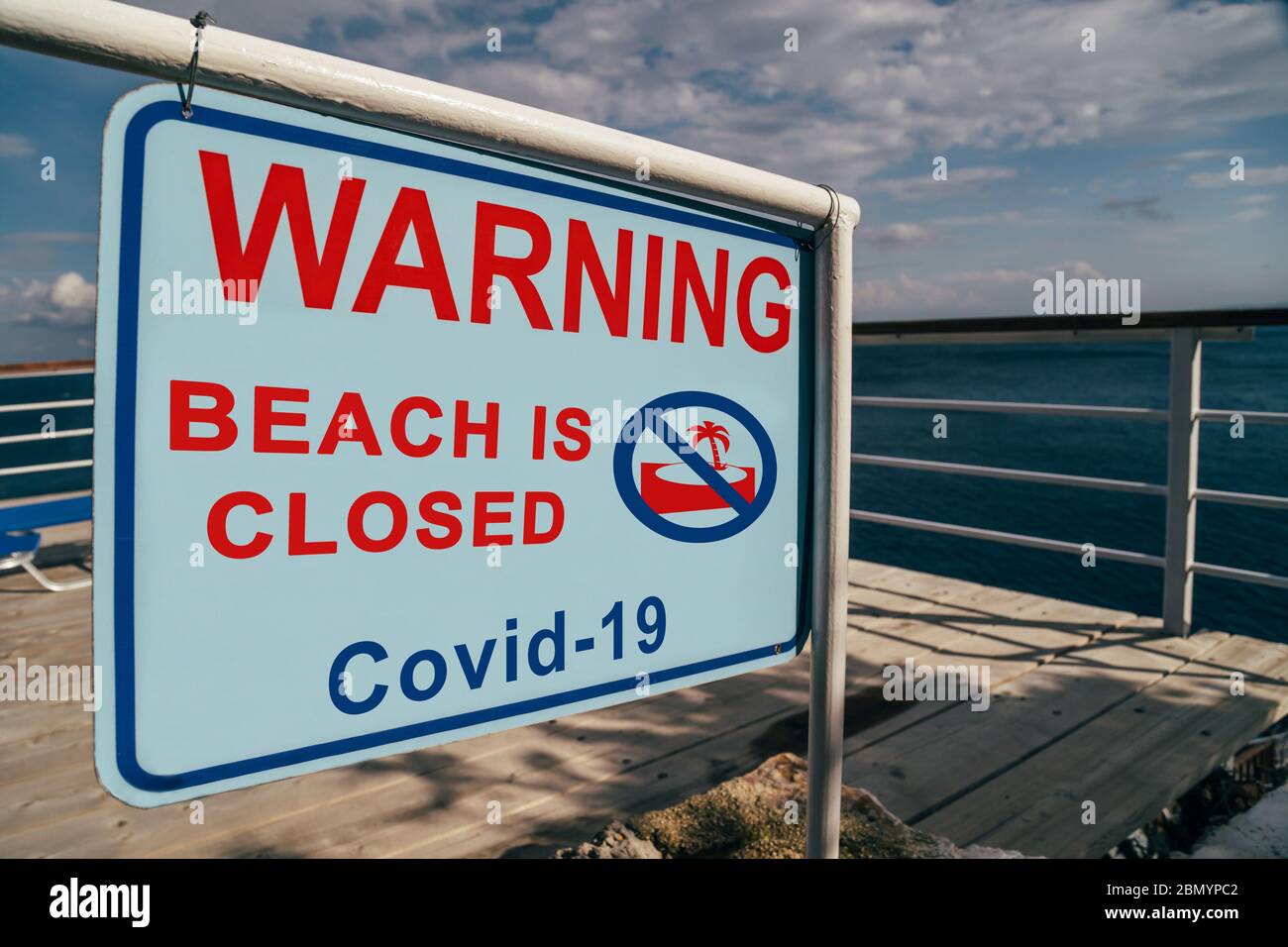 Der Strand ist wegen des Covid-19 Warnschildes am Eingang zum Strand geschlossen. Social Media Kampagne zur Prävention von Coronaviren. Urlaub wird storniert Stockfoto