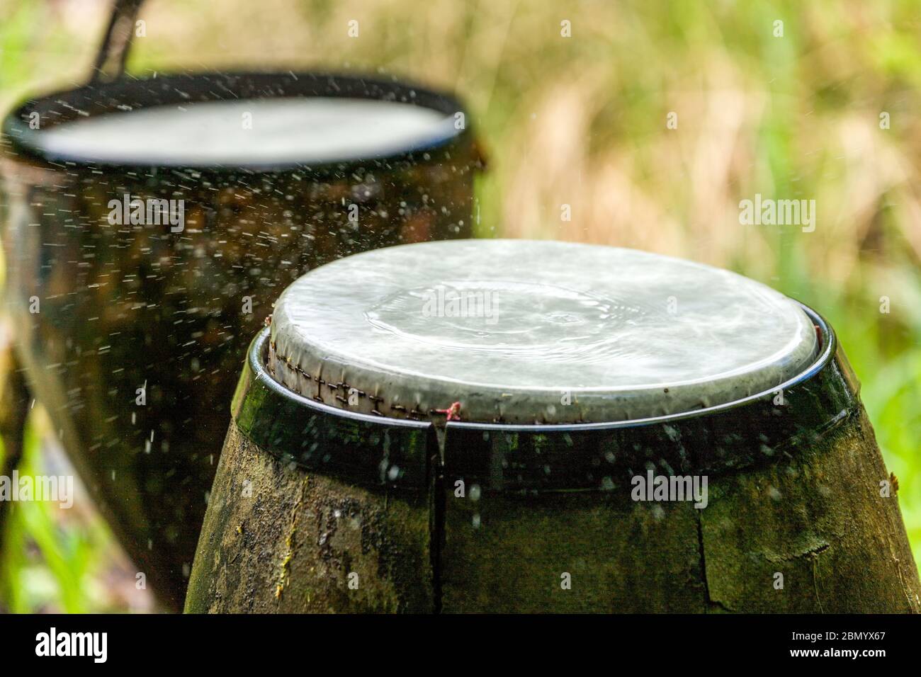 Eine Sammlung von Trommeln schlagen mit Hilfe eines computergesteuerten Bewässerungssystems, das einen Rhythmus von Wassertropfen auf die Trommeln auslöst Stockfoto